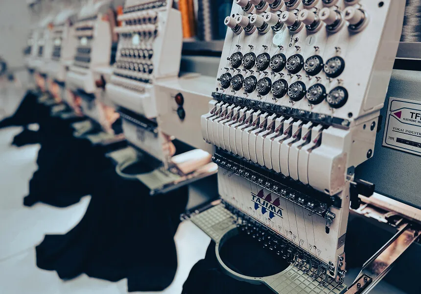 Multi-head embroidery machines working on garments inside the Ad It Up production shop